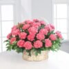 Flores de claveles rosas en canasta de condolencias con diseño floral elegante